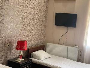 库塔伊西Hotel Mariana的一间卧室设有两张床,墙上配有电视。