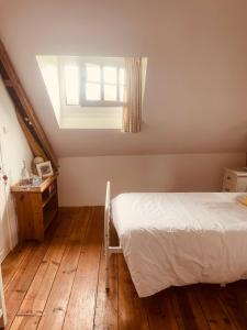 GuerlédanTrevejean chambre d'hotes de charme的一间卧室设有一张床和一个窗户,铺有木地板