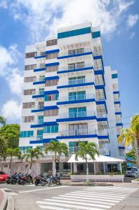 圣安德烈斯加勒比海太阳鲜花酒店 的一座高大的建筑,前面有棕榈树