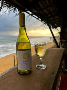 高尔Indika Beach Villa的一瓶葡萄酒和一张桌子上的一杯