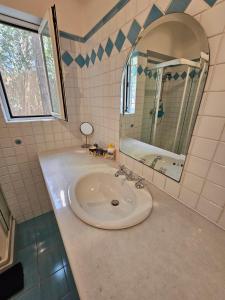 福特村Villetta in stile mediterraneo的一间带水槽和镜子的浴室