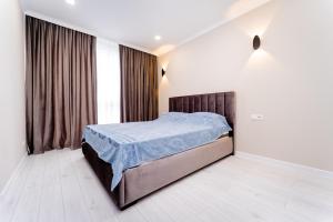 基希讷乌2-Bedroom Family Grandeur Apartment的一间卧室配有一张带蓝色棉被的床