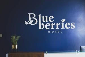 恩德培Blueberries Hotel的蓝色的优惠酒店标志,在蓝色的墙上