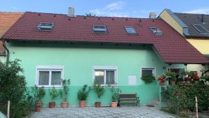 贡特拉姆斯多夫100qm comfort, family-friendly and top located的一座绿色房子,有红色屋顶和盆栽植物
