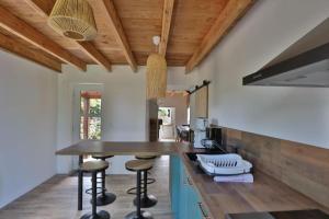劳恩尼克Gîte Louannec - Ty Bleiz的厨房设有木制天花板和带凳子的台面。