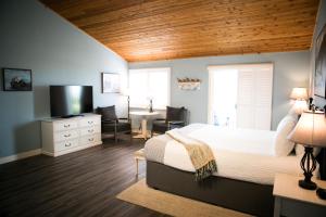 坎布里亚海獭酒店的一间卧室配有一张床、一张书桌和一台电视