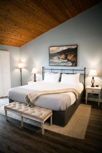 坎布里亚海獭酒店的一间卧室配有一张大床、两张桌子和两盏灯。