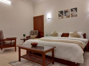 AmmattiThe Cana's Coorg的酒店客房设有一张大床和一张桌子。