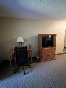 Walker沃克乡村酒店的客房设有书桌、电视和椅子。