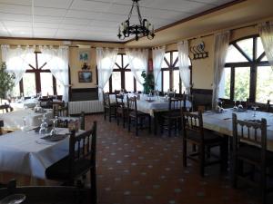 瓜达莱斯特里根迪贝佩旅舍的餐厅设有白色的桌椅和窗户。