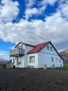 霍芬Sauðanes Guesthouse的一座大型白色房屋,设有红色屋顶