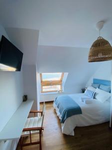 拉科鲁尼亚EL TRASTERO DE PALMERO的一间卧室设有一张床、一台电视和一个窗口。