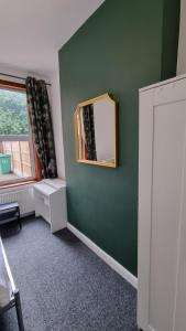 诺丁汉Double Room With Kitchen Facilities的一间设有镜子和绿色墙壁的客房