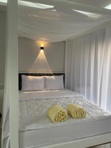 卢克索Royal Nile Villas - Nile View Apartment 1的一张白色的床,上面有两个黄色的枕头