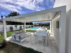 Leporano MarinaCasa del Sol Luxury Estate Puglia的一个带桌椅的庭院和一个游泳池