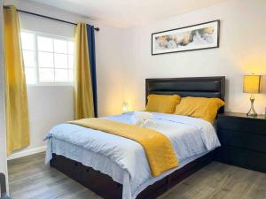 圣何塞NEW 3BR/2BA house SJ Silicon W/D parking的一间卧室配有一张带黄色床单的床和一扇窗户。