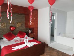 卡利HOTEL BOUTIQUE LUXURY的一间卧室配有一张带红色枕头和气球的床。