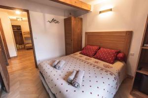 圣拉里苏朗Le Rioumajou 2的一间卧室配有一张带红色枕头的大床
