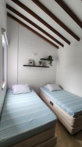 圣菲德安蒂奥基亚Apartasol Ciudadela Santafe - Santa Fe de Antioquia的两张睡床彼此相邻,位于一个房间里