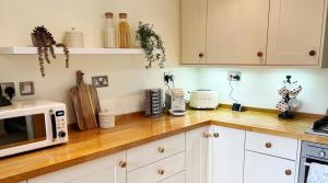 埃文河畔斯特拉特福Traditional 2 bedroom Cottage的厨房配有白色橱柜和木制台面