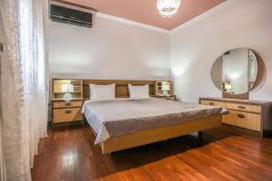 卡兰巴卡SOCRATES Ethnic and traditional Home的一间卧室配有一张大床和镜子