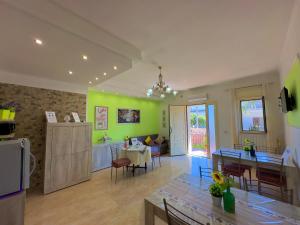 莱波拉诺B&B Afrodite的一间厨房和带绿色墙壁及桌子的客厅