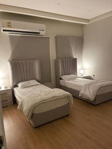 阿可贺巴Family Furnished Apartment in Khobar的一间卧室配有两张床和空调。