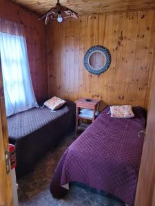 Coronel MoldesCabaña Los Abuelos的一间卧室配有两张床和一张带镜子的桌子