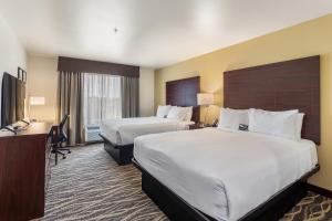 De PereCobblestone Hotel & Suites - De Pere Green Bay的酒店客房配有两张床和一张书桌