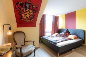 杜伊斯堡- Magical Harry Potter apartment in Duisburg - 2 Mins Central Station Hbf - Kingsize Bed & Netflix -的一间卧室配有床、椅子和国旗