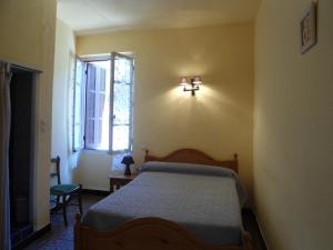 皮亚纳Hotel Les Calanques的卧室配有一张床,墙上有灯