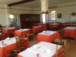 皮亚纳Hotel Les Calanques的一间空餐厅,配有红色的桌椅