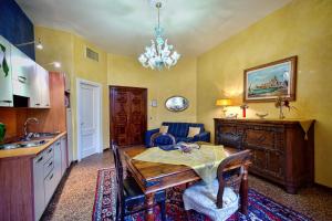 威尼斯奥多尼公寓式酒店的厨房配有餐桌和吊灯。