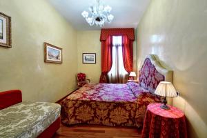 威尼斯奥多尼公寓式酒店的一间卧室配有一张床,窗户配有吊灯