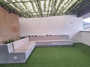 马尼萨莱斯Confortable apartamento的配有长凳和绿草的房间