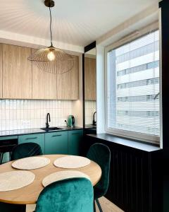 克拉科夫Stańczyka Apartment的厨房配有木桌和绿色椅子