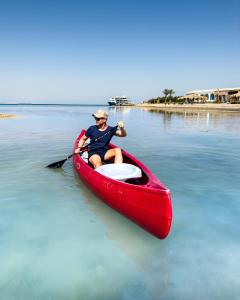 赫尔格达Gravity Hotel & Aqua Park Hurghada Families and Couples Only的水里一个红独木舟的人