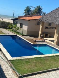 MaceióBeira-mar Chalé Maceió - Camocim的蓝色游泳池毗邻房子和海滩