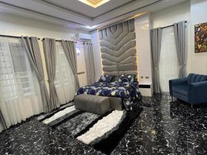 莱基Luxury 4 bedroom duplex的一间卧室配有一张大床和一张蓝色椅子