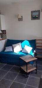 拉康提内勒L'Escale Cotinarde的客房内的蓝色沙发、枕头和桌子