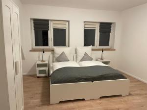 施内沃丁根Ferienwohnung Wintermoor的带2扇窗户的客房内的一张白色床