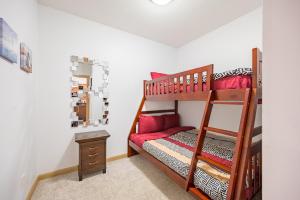 基洛纳Resort Style Living with Private Lawn and Patio的儿童卧室配有带红色枕头的双层床