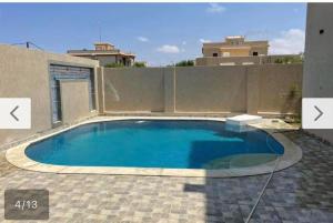 Naj‘ al Aḩwālفيلا محمد بدر的后院的大型游泳池,带围栏