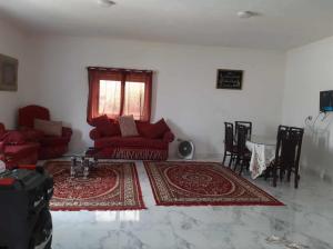 Naj‘ al Aḩwālفيلا محمد بدر的客厅配有红色沙发和地毯。
