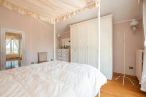 奥西莫La Gipsofila Attic的一间卧室配有一张带天蓬的白色床