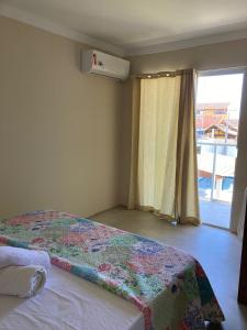 瓜拉派瑞POUSADA RECANTO DULE的一间卧室设有一张床和窗户