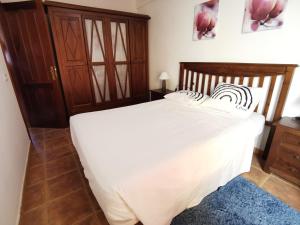 拉卡莱塔Alma y Sol的卧室配有白色的床和木制床头板