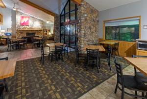 Silver BayBlack Beach Inn by GrandStay的一间带桌椅和石墙的餐厅