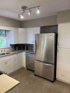 伯纳比Cozy Capitol Hill Bungalow - 3BD/2BA Retreat的厨房配有不锈钢冰箱和白色橱柜