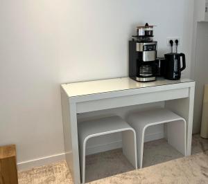 芒德Domaine de Mende Brenoux Suites & SPA的一张白色桌子,上面配有咖啡壶